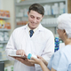 Pharmacist talking to a client about prescribed medications. - PhotoDune Item for Sale