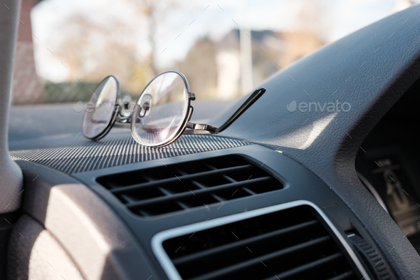 Glasses on the dashboard of a car. Accessory for drivers with vision problems. Road safety concept. - Stock Photo - Images