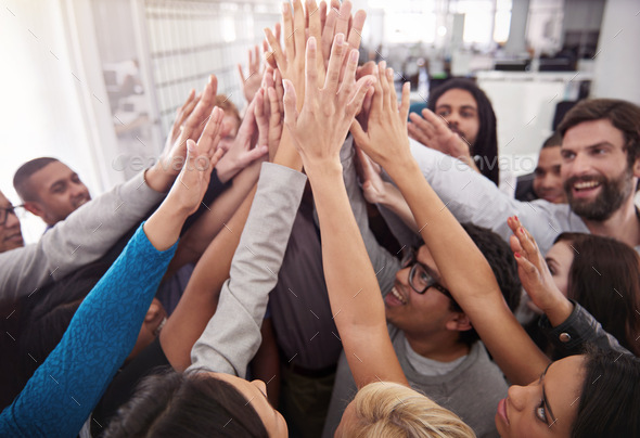 Way to go, team. Shot of a business team raising their hands while standing in a huddle.
