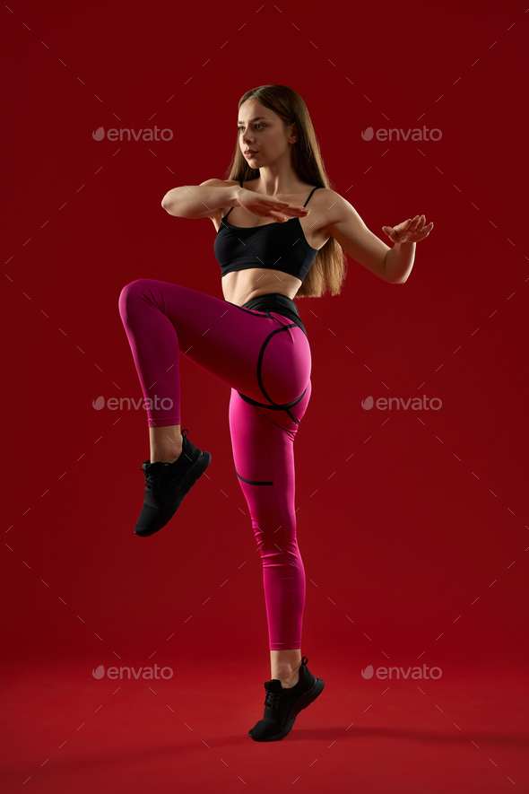 Athletic woman with long hair jumping keep balance by hands.