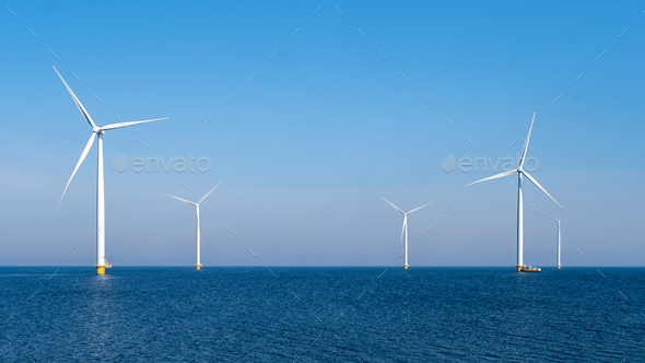 Windmill turbines at sea a huge winmill park in the Netherlandswit a blue sky - Stock Photo - Images