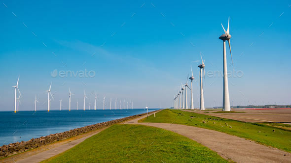 Windmill turbines at sea a huge winmill park in the Netherlandswit a blue sky - Stock Photo - Images
