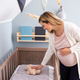 Pregnant woman preparing crib for expected newborn baby - PhotoDune Item for Sale