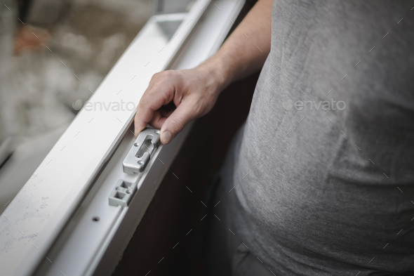 Caucasian man holding fittings for a window frame.