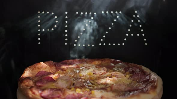 Delicious Fresh Italian Pizza On  A Black Background With The Effect Of Light Inscription Pizza