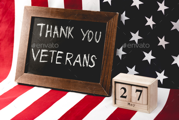 black board with thank you veterans lettering near flag of america and cubes with date