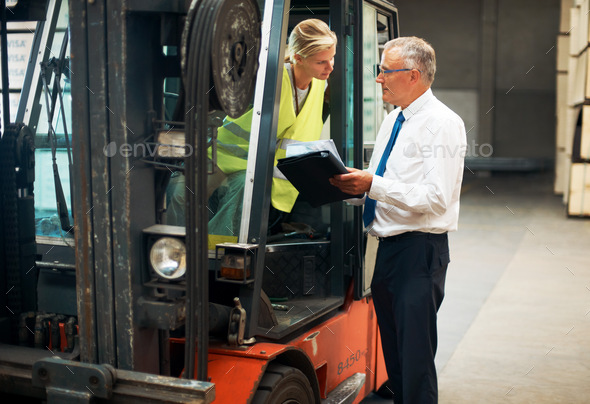 Listen and learn from the best. A manager giving orders to an employee whos sitting on a forklift.
