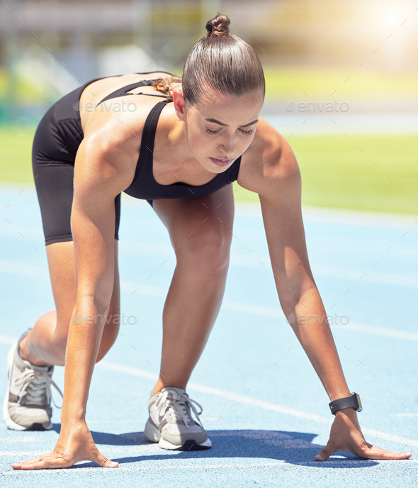 Runner, woman and focus of a athlete about to start a run on a sport track outdoor. Fitness, sports