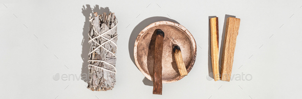 Items for spiritual cleansing - sage bundle, palo santo incense sticks and quartz crystal. Banner