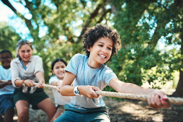 Shot of a group of teenagers playing a game of tug of war at summer ...