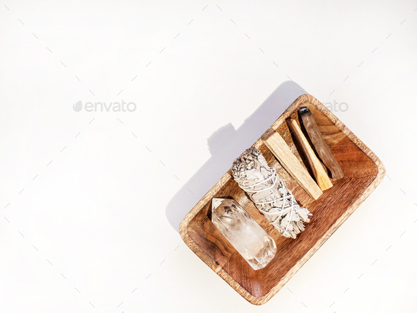 Items for spiritual cleansing - sage bundle, palo santo incense sticks and quartz crystal