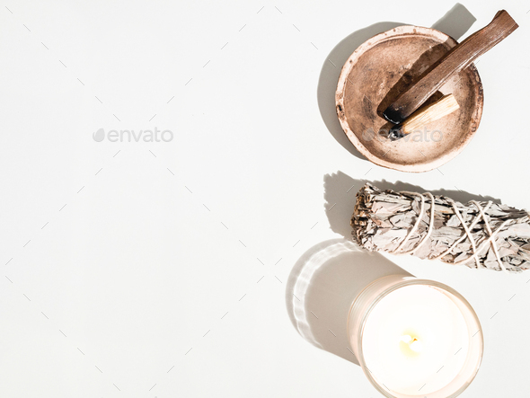 Items for spiritual cleansing - sage bundle, palo santo incense sticks and candle