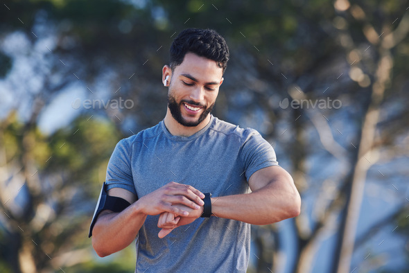 A runner with fitness smartwatch, app and check running time for health tracking tech on nature run