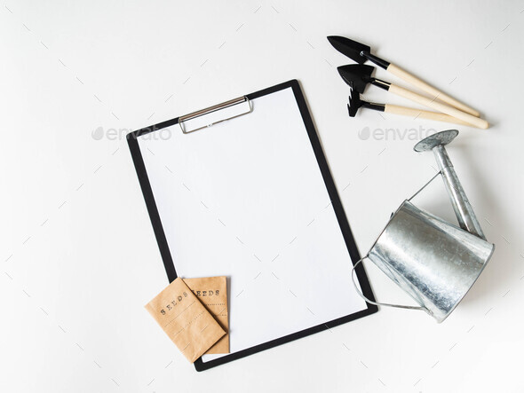 Clipboard and paper for text, garden tools and seeds in paper bags