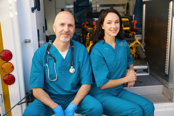 Man and woman sit on edge of hospital admission vehicle - Stock Photo - Images