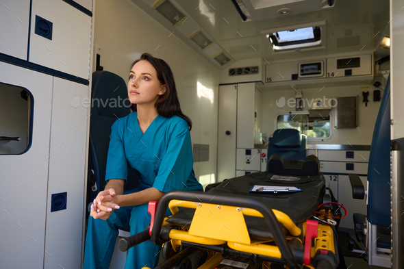 Woman from the emergency medical team thought in a car
