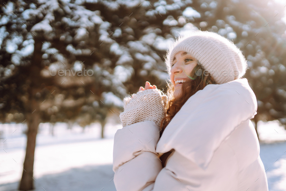 Happy woman in winter style clothes walking in the snowy park. Nature,  holidays, travel concept. Stock Photo by maxbelchenko