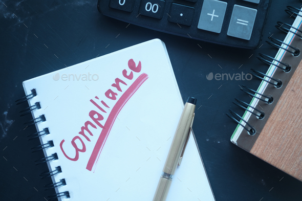 close up of hand written Compliance text on notepad  - Stock Photo - Images
