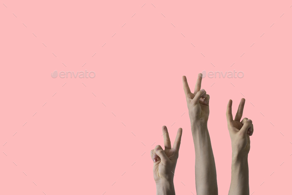 a large group of people rise hands and show peace sign, no war concept ...