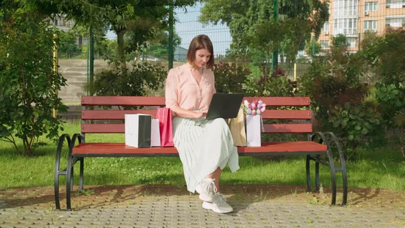 Happy Female Using Laptop Outdoors