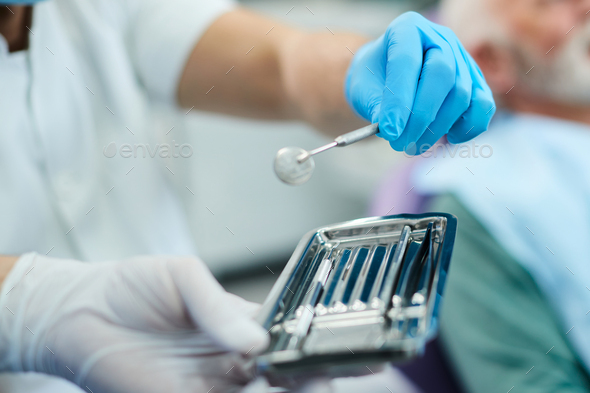 Close-up of dentist using angled mirror during dental procedure,