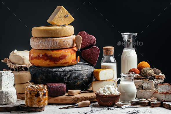Different homemade cheeses on a dark background. farmer market. banner, menu, recipe place for text