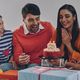 Happy young people congratulating friend with birthday while celebrating together at home - PhotoDune Item for Sale