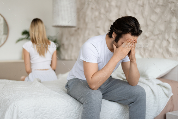 Relationship crisis. Caucasian man feeling upset after fight with his wife, sitting back to back on