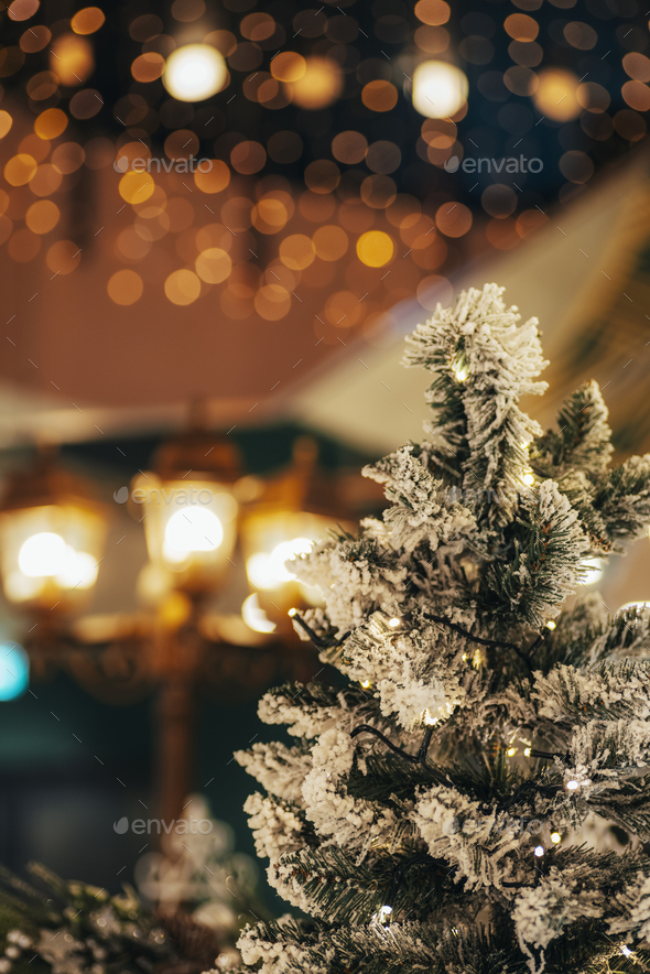 Christmas tree with snow and Christmas decorations, bokeh lights
