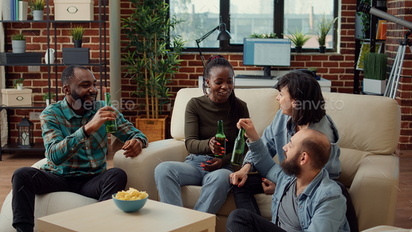 Diverse group of friends clinking bottles of beer to make toast