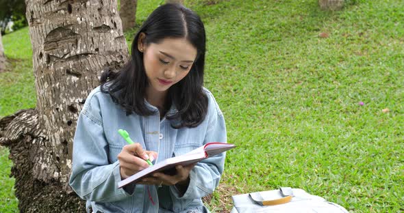 Asian Girl Student Writing Something On Notebook alt