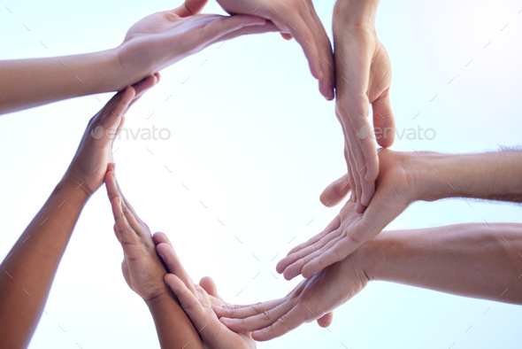 Shot of a group of people creating a circular form with their hands together