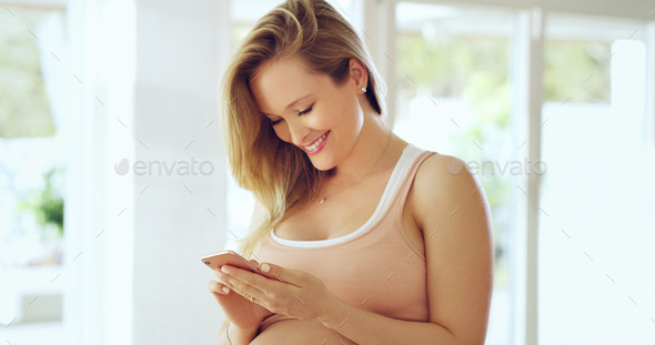 She loves staying in touch with loved ones. Shot of a pregnant woman using a cellphone at home.