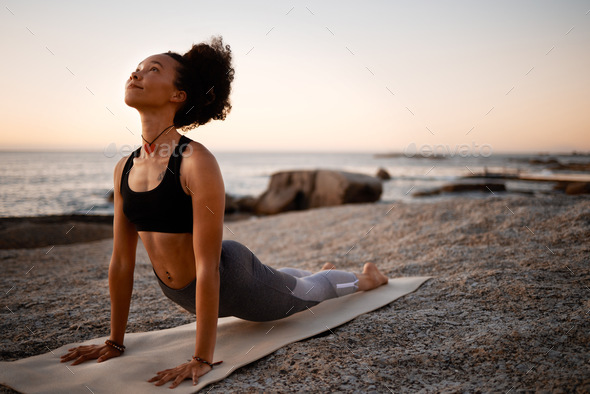Full length of a slim woman practicing yoga standing on a mat by ocean  stock photo (264666) - YouWorkForThem
