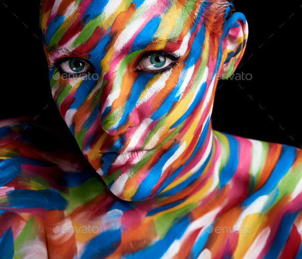 Clothed in colour. Cropped portrait of a young woman posing with paint on her face.