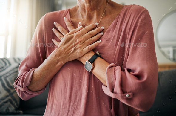 Senior woman, hands or chest pain in heart attack, anxiety or panic in house or home living room. Z