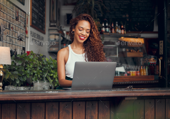 Remote work, laptop and woman at restaurant typing blog article with satisfied and happy smile. Fre