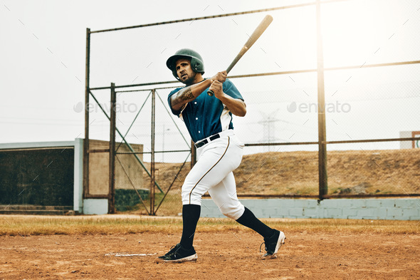 Baseball man, game face and hit ball with bat on a sport field in a game. Sports player with practi