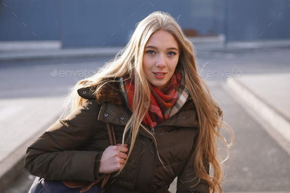 candid street style portrait of teenage girl waiting at bus stop