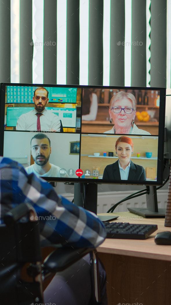 Disabled manager in wheelchair talking during videocall Stock Photo by