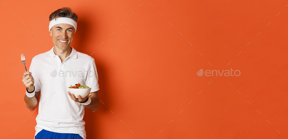 Concept of sport, fitness and lifestyle. Image of handsome, healthy and active male athlete, eating