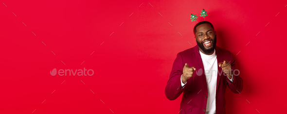 Merry Christmas. Handsome african american man in blazer and party headband, celebrating new year
