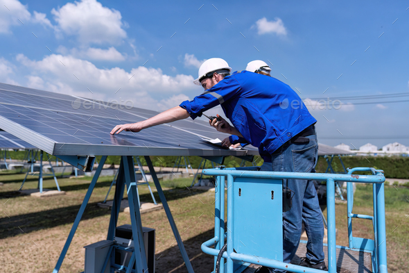 Maintenance engineer at solar farm stand on scissor lift routine inspection solar panel condition
