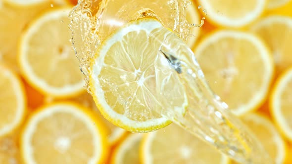 Super Slow Motion Shot of Splashing Water on Rotating Lemon Slice at 1000Fps alt