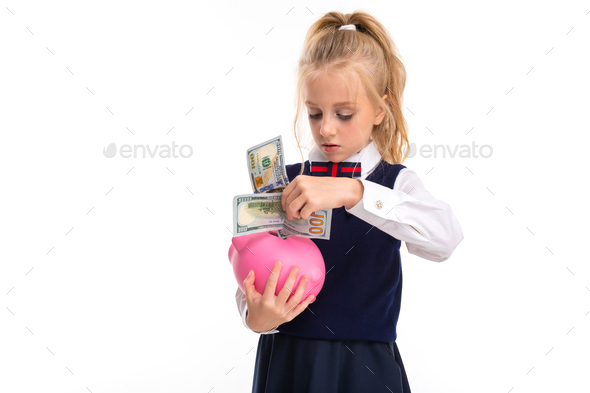 A little girl with blond hair stuffed in a horse tail, large blue eyes and a cute face folds dollars