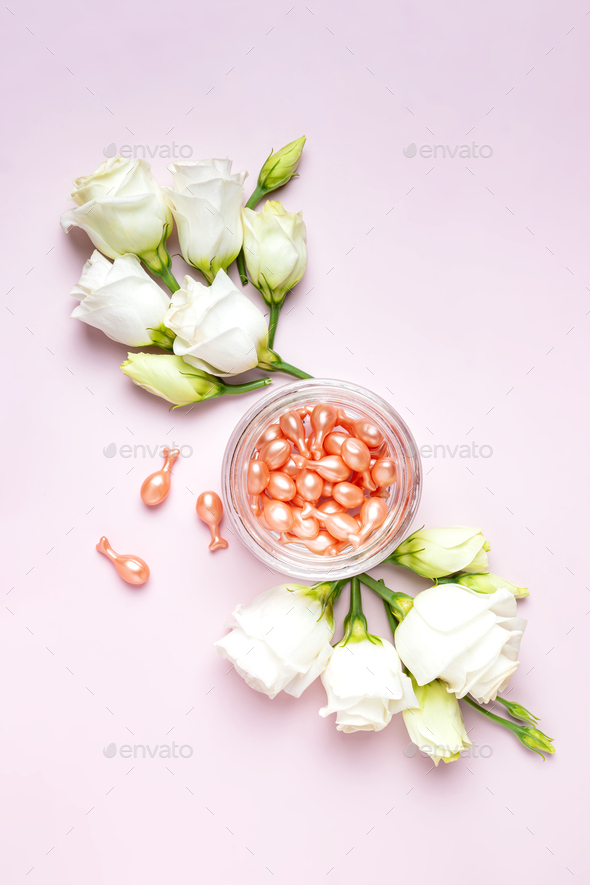 face care oil capsules on pink background. single use nourishing oil for dry and damaged skin.
