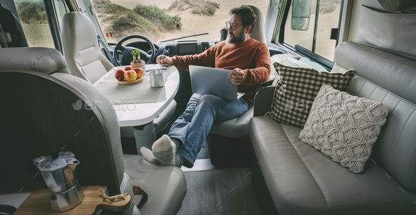One alone man sitting and relaxing inside a camper van alternative home vanlife lifestyle off grid