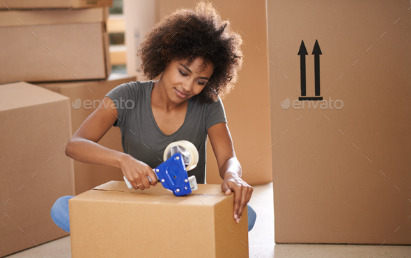 Heres to a new start. Shot of a young woman moving into her new house.
