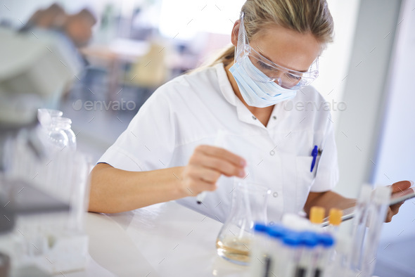 Testing a theory. A young scientist conducting an experiment in her lab. - Stock Photo - Images