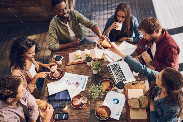 Shot of a group of creative workers having a meeting over lunch in a cafe - Stock Photo - Images